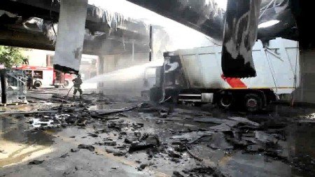 Vigili del fuoco domano le fiamme su un mezzo della nettezza urbana