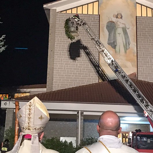 I Vigili del fuoco issano sulla croce una corona di fiori