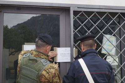 I Carabinieri affiggono il cartello di chiusura del locale