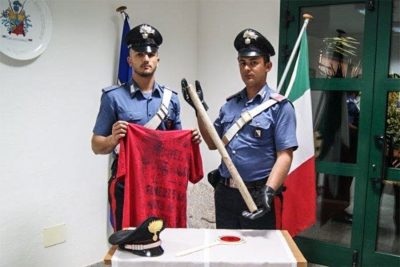 I Carabinieri con il bastone utilizzato per il pestaggio