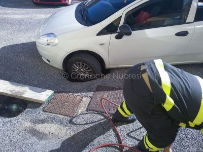L'auto con la ruota dentro la buca (foto Cronache Nuoresi)