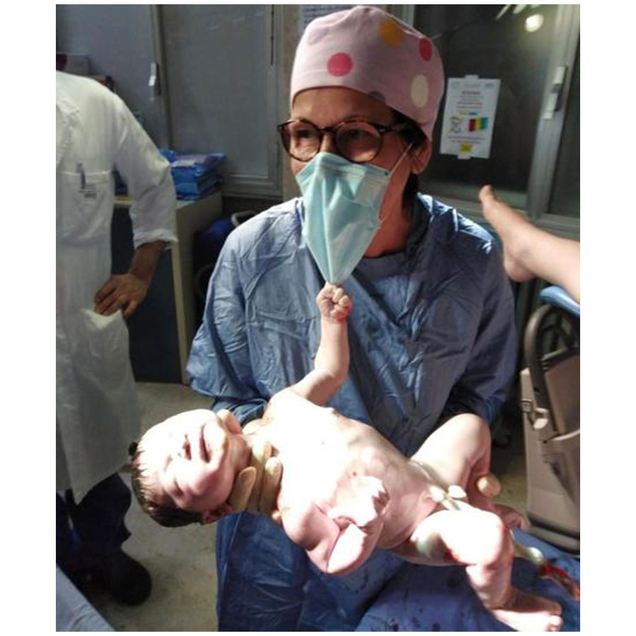 Neonato strappa la mascherina all’ostetrica: è la foto simbolo del Natale 2020